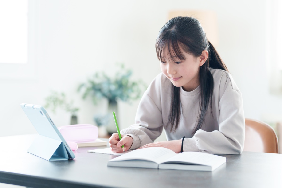 タブレットを見ながら勉強する女の子